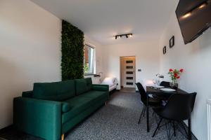 a living room with a green couch and a table at Pokoje Na Winklu in Kluszkowce