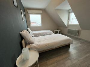 1 dormitorio pequeño con 2 camas y mesa en Sérénité alsacienne, en Seltz
