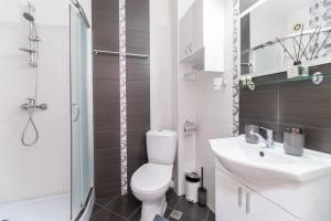 La salle de bains est pourvue de toilettes, d'un lavabo et d'une douche. dans l'établissement Chic Urban Retreat: Modern 2-Bedroom Gem for Your City Escape, à Plovdiv