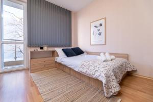 a bedroom with a bed and a window at Chic Urban Retreat: Modern 2-Bedroom Gem for Your City Escape in Plovdiv