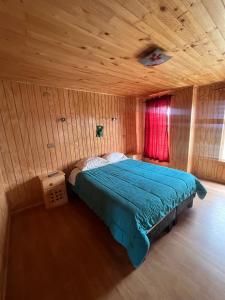 ein Schlafzimmer mit einem Bett in einem Holzzimmer in der Unterkunft Los Dudys in Castro