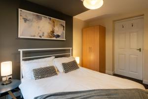 a bedroom with a bed with two pillows on it at Aryas Apartments Oxford - Headington in Oxford