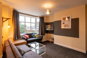 a living room with a couch and a window at Aryas Apartments Oxford - Headington in Oxford