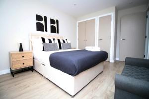a bedroom with a large bed and a chair at 2 BR and Free parking in Cardiff