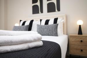 a bedroom with two beds with white and gray pillows at 2 BR and Free parking in Cardiff