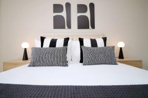 a bedroom with a white bed with black and white pillows at 2 BR and Free parking in Cardiff