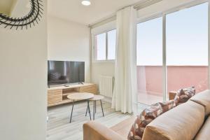 a living room with a couch and a tv at Alcam Baro SA in Barcelona