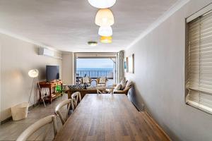 巴利托的住宿－Sunny Beach Front Apartment，客厅设有一张长桌,享有海景。