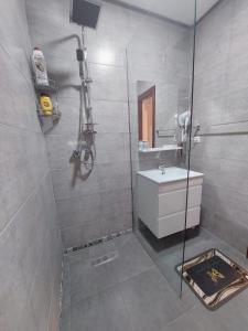 La salle de bains est pourvue d'une douche, d'un lavabo et d'un miroir. dans l'établissement Charite Host Appartement , Wifi et Parking Gratuit, à Agadir