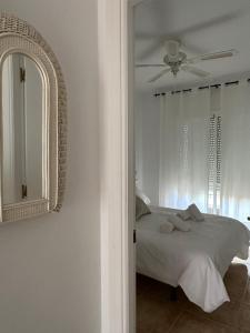 Schlafzimmer mit einem Bett, einem Deckenventilator und einem Spiegel in der Unterkunft Tiyoweh in Nerja