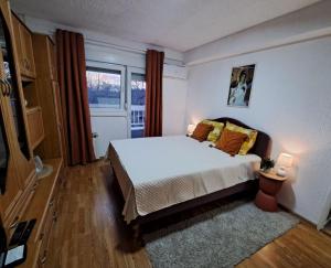 a bedroom with a white bed and a window at Apartment White Angel in Kostolac