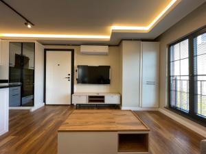 Una sala de estar con un televisor de pantalla plana y una mesa. en ARC HOUSE, en Estambul
