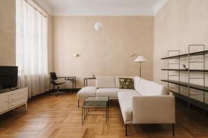 uma sala de estar com um sofá branco e uma televisão em HERE Apartments em Cracóvia