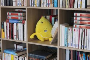un animal de peluche amarillo sentado en una estantería de libros en Hotel Pavillon Imperial en Menton