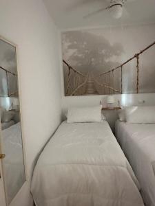 2 Betten in einem Zimmer mit einem Brückenbild an der Wand in der Unterkunft Tiyoweh in Nerja