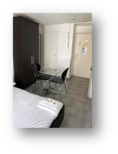 1 dormitorio con 1 cama, mesa y sillas en Résidence Le Patricia, en Grenoble