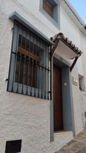 un balcón en el lateral de un edificio con una puerta en Casita de la Alegría en La Puerta de Segura