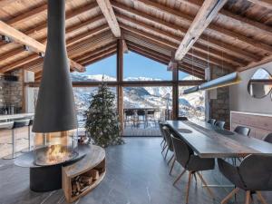 jadalnia z kominkiem, stołem i krzesłami w obiekcie Chalet de prestige avec jacuzzi, sauna et cinéma - FR-1-570-42 w mieście Saint-Martin-de-Belleville