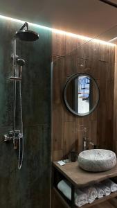 La salle de bains est pourvue d'une douche, d'un lavabo et d'un miroir. dans l'établissement Котедж Gudz, à Yaremtche