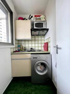 a kitchen with a washing machine and a microwave at The coziest 1B&B near l'Etoile (Arc de Triomphe) in Levallois-Perret