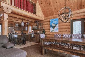 a kitchen and living room with a table in a cabin at Nouveau - 3CH : Ski-in / Ski-out & foyer in Saint-Apollinaire