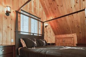 a bedroom with a bed in a wooden room at Nouveau - 3CH : Ski-in / Ski-out & foyer in Saint-Apollinaire