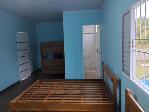 a bedroom with blue walls and a bed in a room at Chácara Rodrigues in Piedade