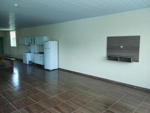 an empty room with a refrigerator and a tile floor at Chácara Rodrigues in Piedade