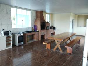 una cocina con mesa de madera y un horno de ladrillo en Chácara Rodrigues, en Piedade