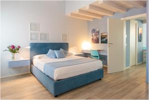 a bedroom with a blue bed and a desk at Tiffany Home in Burano