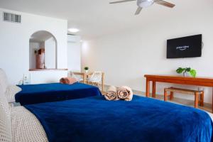 2 camas con sábanas azules en una habitación en Preciosas vista al mar, a 10 min. del aeropuerto -Sol2401- en Cancún