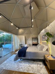 a bedroom with a large bed in a tent at GOAT LODGE Domo Pitanga in Ibiúna