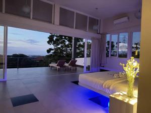 una grande camera da letto con un letto e un balcone di Villa Infinity a Lovina