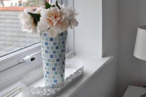 um vaso cheio de flores sentado no peitoril da janela em The Sashes - Apartment One - FREE Parking - Ultrafast WIFI - Smart TV - Netflix - sleeps up to 6! Close to Poole Town Center & Sandbanks & Bournemouth em Poole