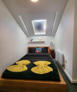 a bedroom with a bed with two yellow pillows at 1Bed Downtown Apt near Anfield Stadium in Liverpool