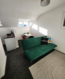 a living room with a green couch and a table at 1Bed Downtown Apt near Anfield Stadium in Liverpool