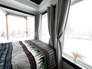 um quarto com uma cama e uma grande janela em ‘Scenic Escapes’ Romantic Pine Grove Getaway! em Pine Grove