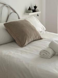 a white bed with a pillow with a towel on it at Tiyoweh in Nerja