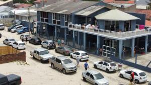 a group of cars parked outside of a blue building at Pousada Felicitá in Imbé