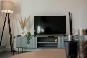a flat screen tv sitting on top of a entertainment center at Charming Colchester House in Colchester