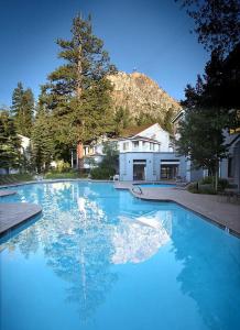 une grande piscine d'eau bleue dans une cour dans l'établissement One Bedroom #101, à Olympic Valley