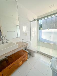 La salle de bains est pourvue d'un lavabo, de toilettes et d'une douche. dans l'établissement Pousada Mansão Triplex Jolly, à Búzios