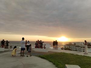 Un groupe de personnes debout pour regarder le coucher du soleil dans l'établissement Bonito Depa, cómodo y bien ubicado, à Punta Hermosa