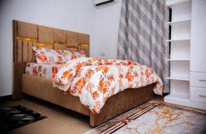 1 dormitorio con 1 cama con edredón de flores en DOMINGO VILLA, en Dar es Salaam