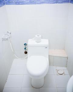 ein weißes WC im Bad mit Dusche in der Unterkunft DOMINGO VILLA in Daressalam