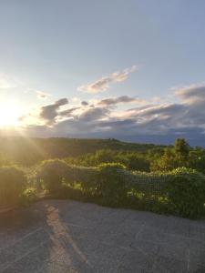 a view of the sun setting over a field at Istria Divina in Marezige