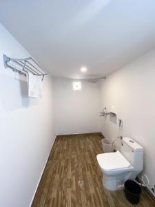 ein Badezimmer mit einem weißen WC und Holzböden in der Unterkunft Luxurious Beach Resort Agonda in Agonda