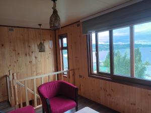 Zimmer mit einem rosa Stuhl und einem Fenster in der Unterkunft Casa Chiloe in Rauco