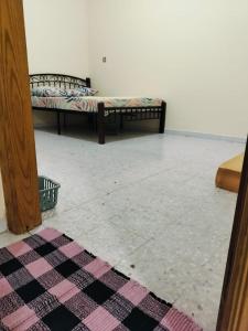two beds in a room with a tile floor at Hussaini Home in Abu Dhabi