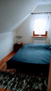 - une chambre avec un lit bleu et une fenêtre dans l'établissement Enklawa Spokoju, 